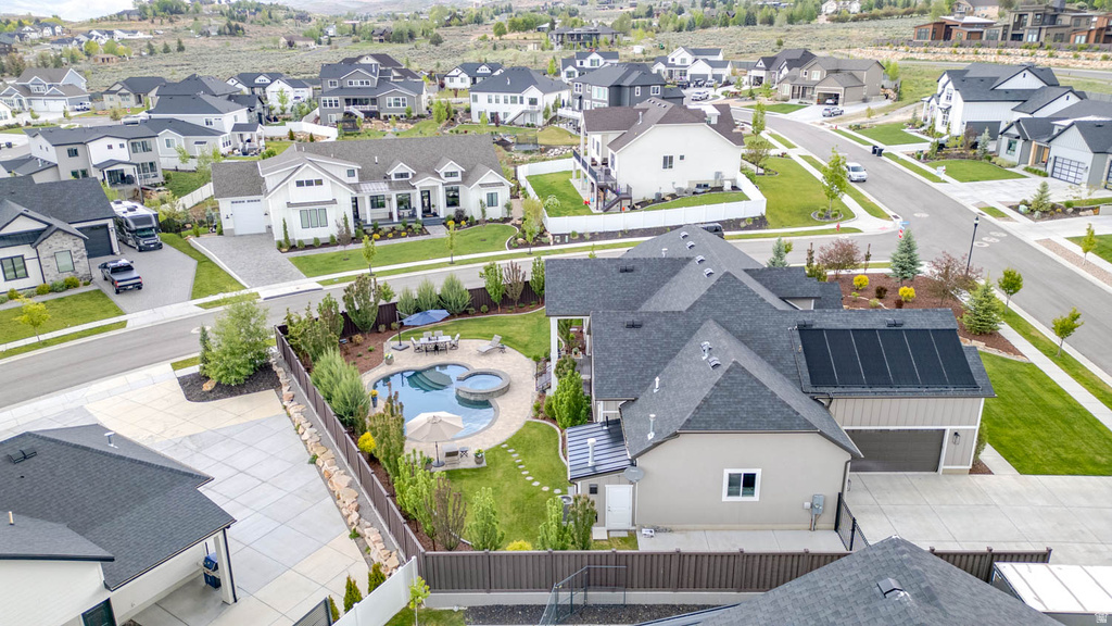 Expansive backyard featuring a freeform swimming pool, integrated spa, and surrounding hardscaping