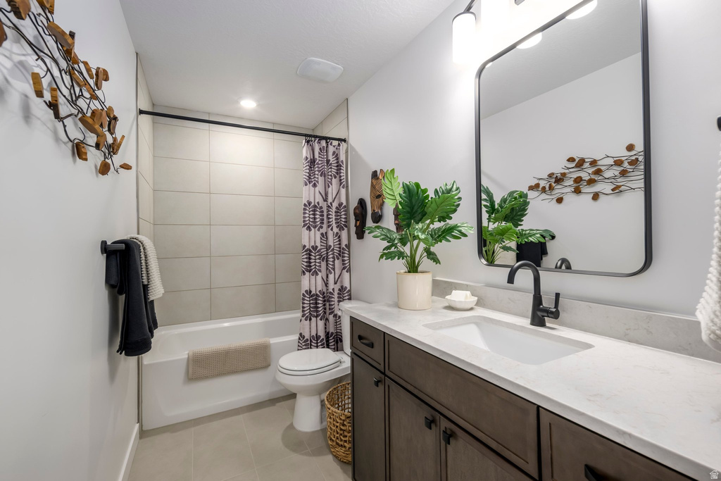 Bathroom featuring a spacious single-basin vanity with an integrated sink, dark wood cabinetry, and a light-toned countertop