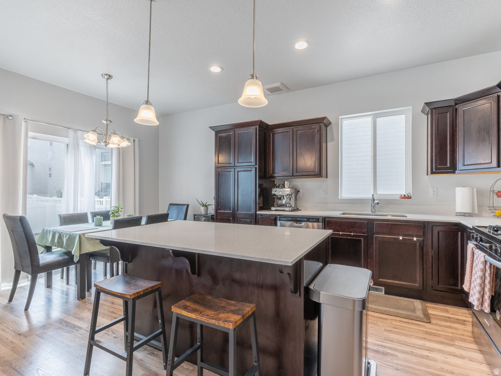 Kitchen featuring wood-finish flooring, dark wood cabinetry, and white countertops