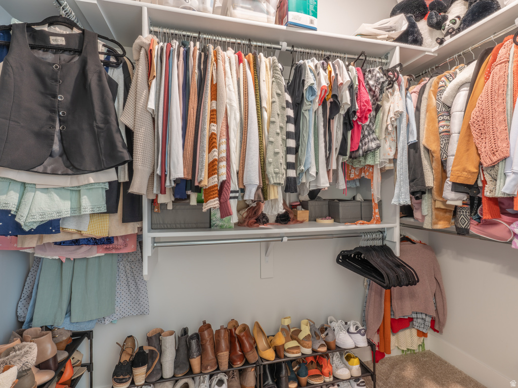 Walk-in closet featuring white shelving, multiple hanging rods, and ample storage space