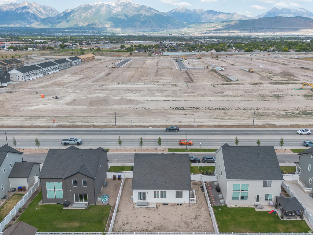 Aerial perspective showcasing residential properties with mountain backdrop and undeveloped land