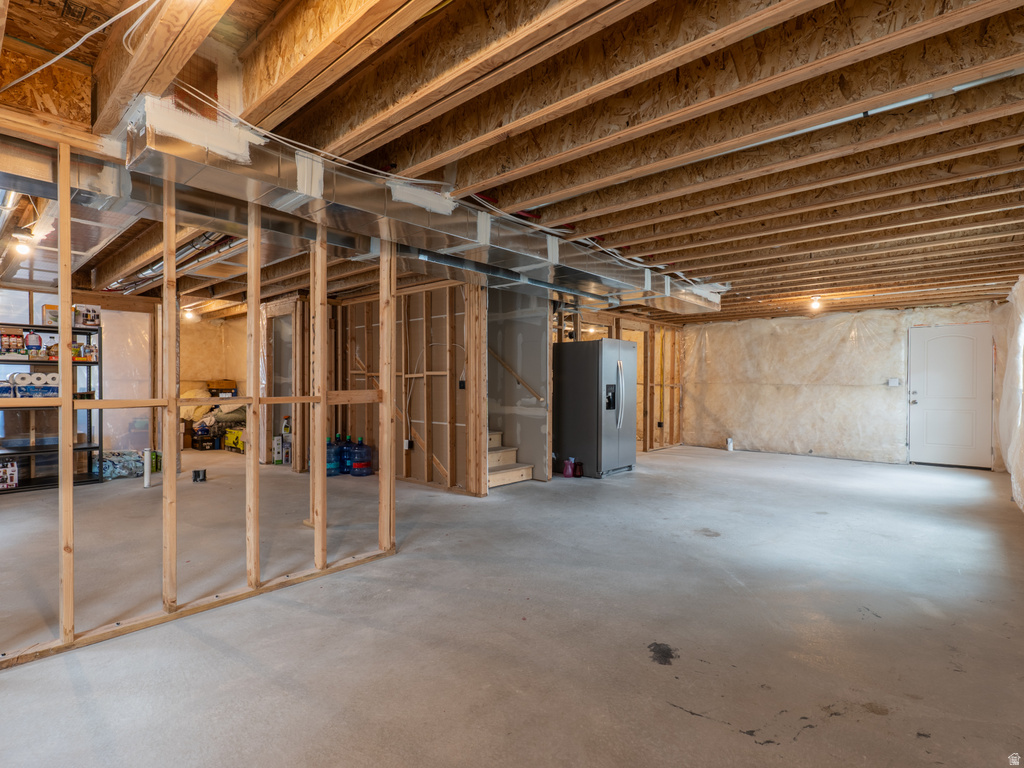 Unfinished basement with concrete flooring and exposed ceiling joists