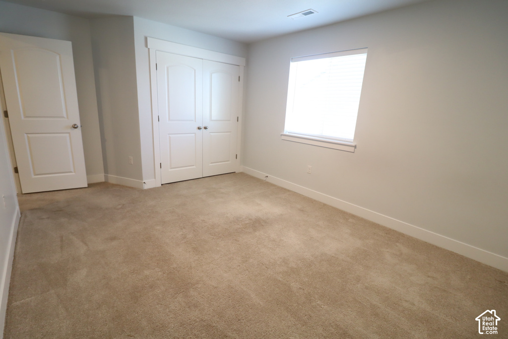 Neutral tone wall paint, light-colored carpet flooring, white trim, white window blind, and white paneled doors