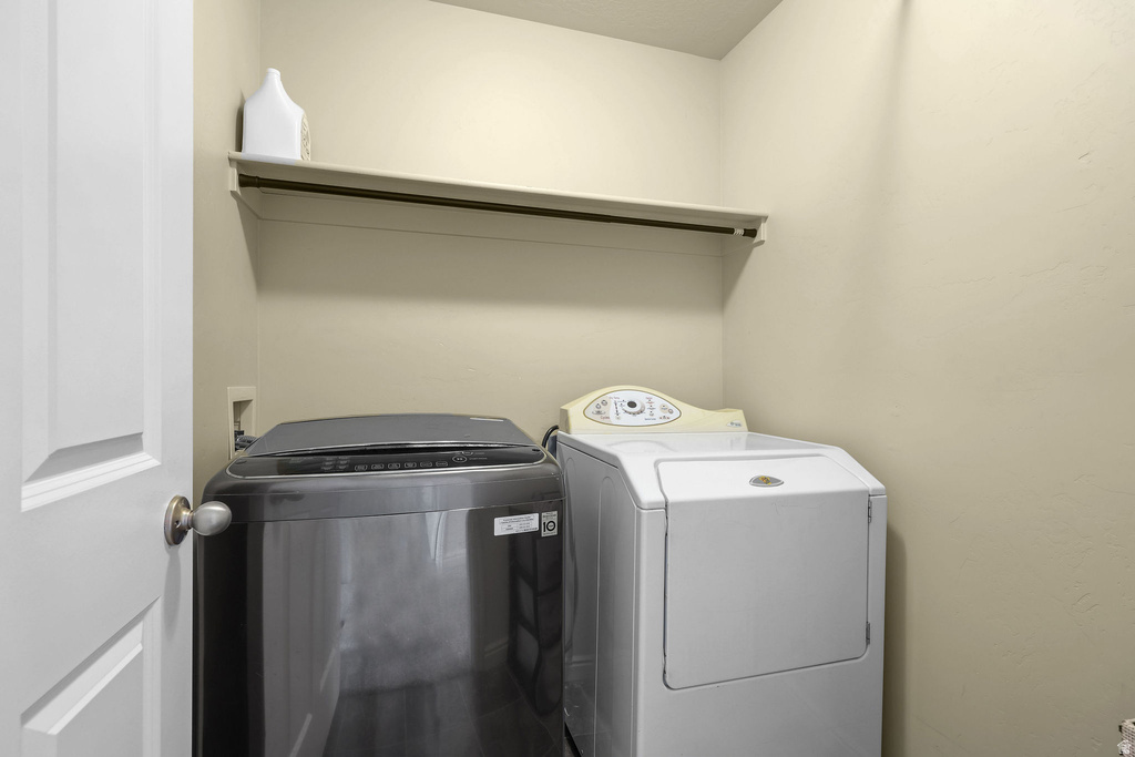 Dedicated laundry area with a white shelving unit and garment rod