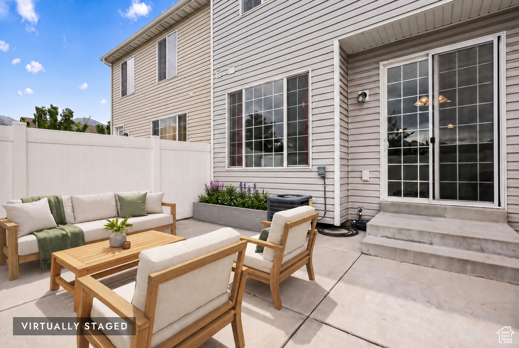 Private concrete patio with white vinyl fencing, sliding glass door entry, and integrated garden planter