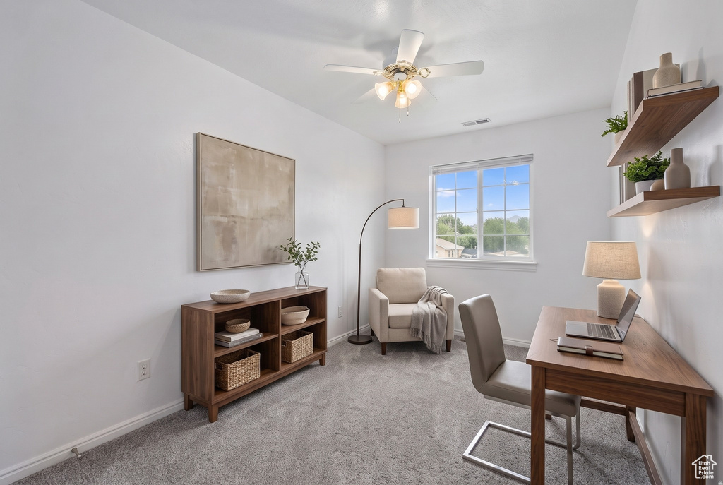 Carpeted interior space featuring a double window, ceiling fan with integrated lighting, and built-in floating shelves
