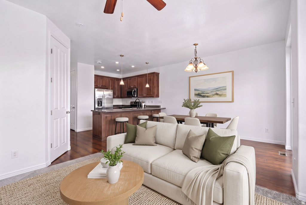 Open-concept living space featuring wood-finish flooring, a contemporary ceiling fan, and recessed lighting