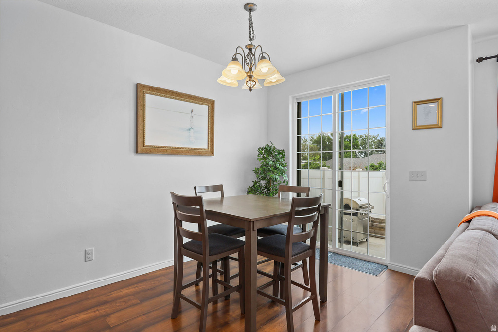 Dining area featuring wood-finish flooring and a contemporary chandelier