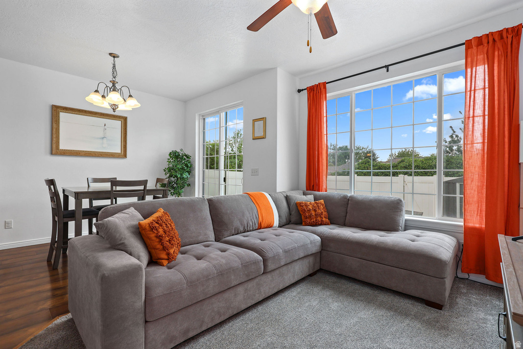 Living area featuring a large window with grid pattern, ceiling fan, and sliding glass door