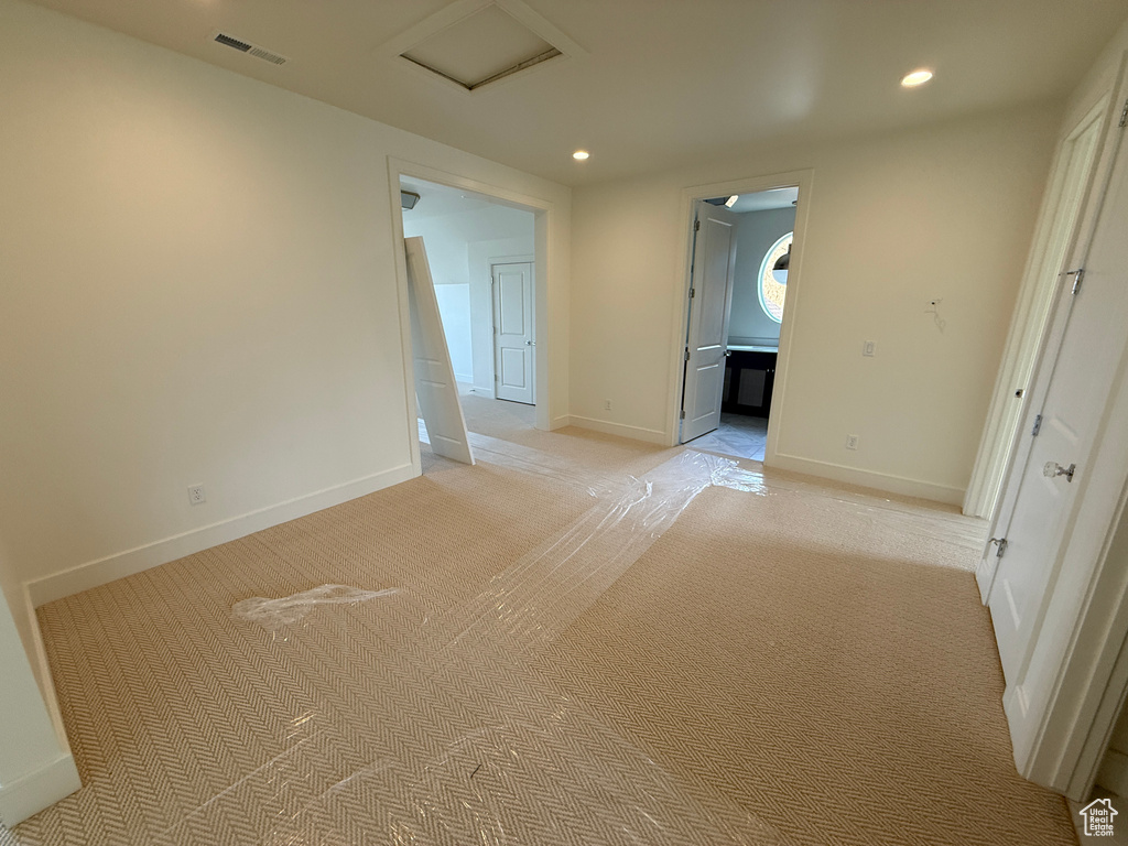 Recessed ceiling lighting, light-toned wall finishes, and patterned carpeting
