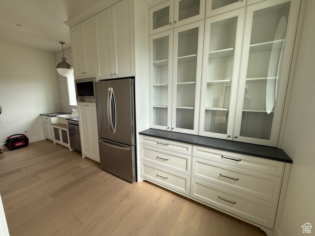 White shaker cabinetry with built-in stainless steel refrigerator and microwave