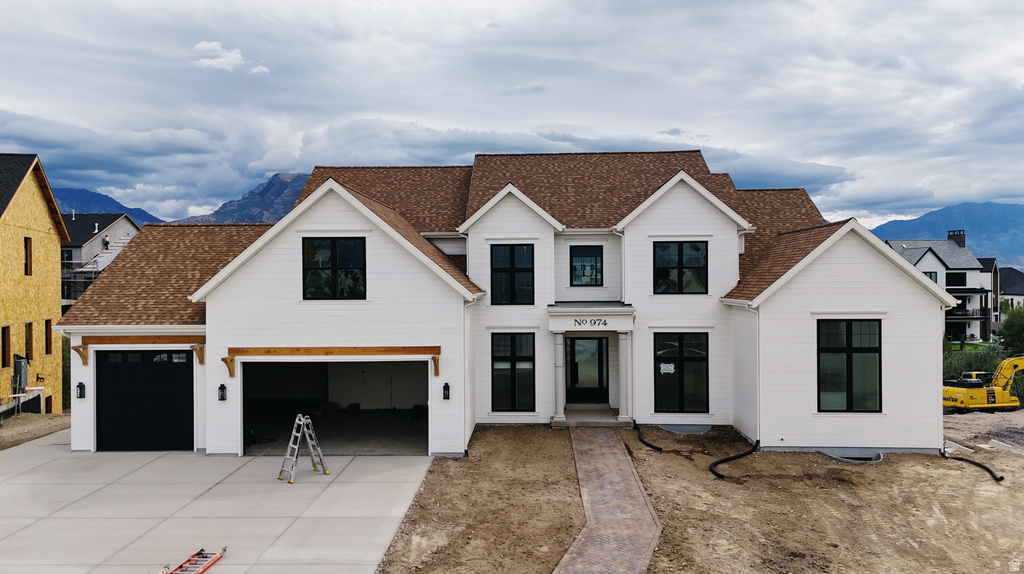 Modern farmhouse architecture with white siding and a brown shingle roof