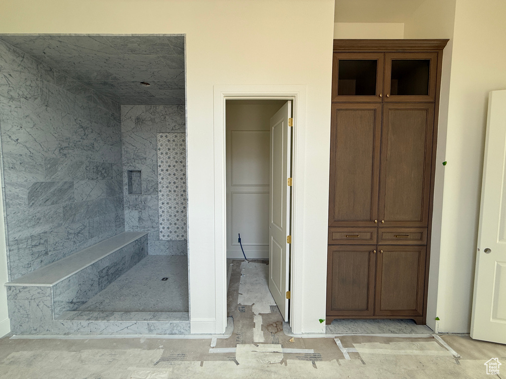 Walk-in shower with full height tile, integrated bench, and mosaic accent