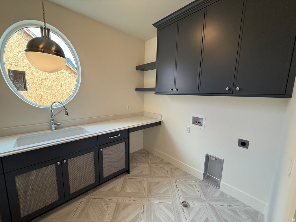 Round window with pendant lighting, integrated sink, wood-finish flooring, and built-in cabinetry