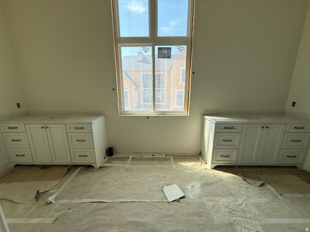 Dual vanity cabinets featuring shaker-style doors and drawers, undermount sinks, and polished hardware