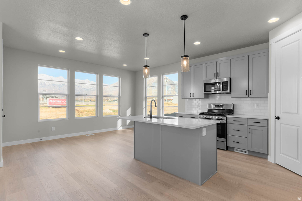Open-concept kitchen and living area featuring light wood-finish flooring