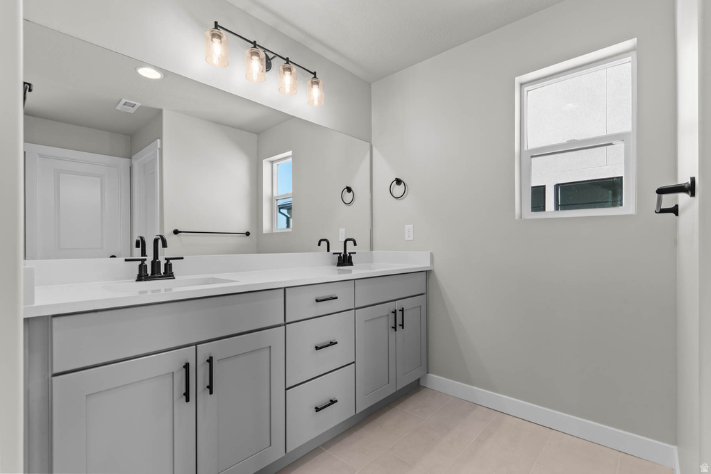 Dual vanity with light gray shaker-style cabinetry, matte black hardware, and white countertops