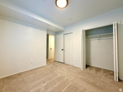 Wall-to-wall carpeting in a neutral tone, white walls, and a ceiling-mounted light fixture