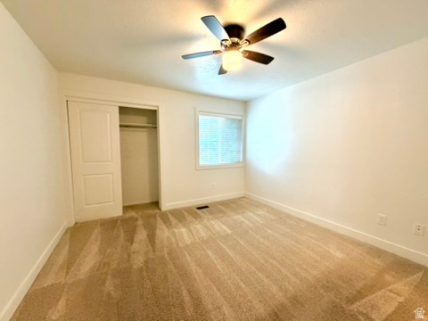 Carpeted room with a ceiling fan light fixture
