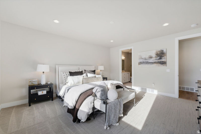 Carpeted bedroom with recessed lighting, white baseboards, and light-colored walls