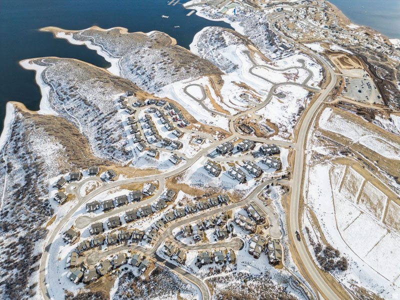 Aerial perspective of a developed residential community featuring multiple homes and winding roads