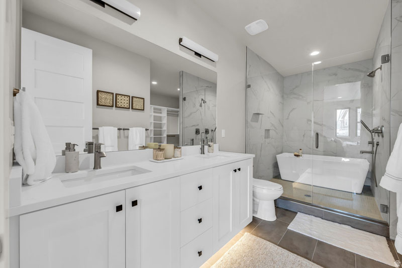 Dual vanity featuring white shaker cabinetry and integrated sinks
