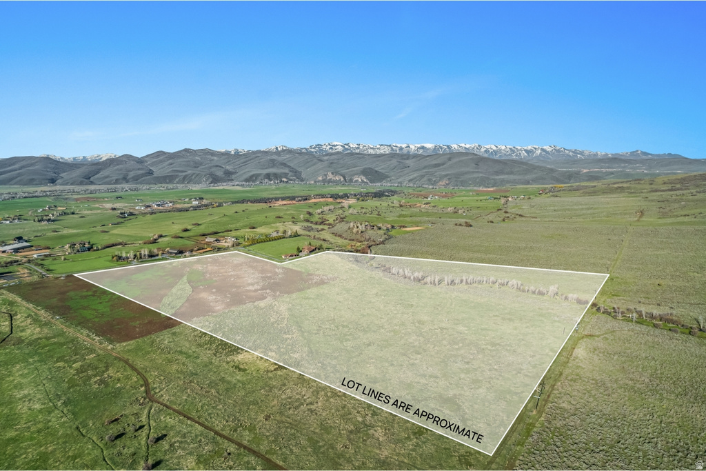 Expansive land parcel featuring open fields and distant mountain ranges