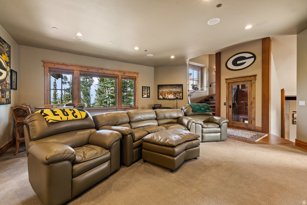 Spacious entertainment room featuring recessed lighting, a large window with natural wood trim, and a built-in wet bar