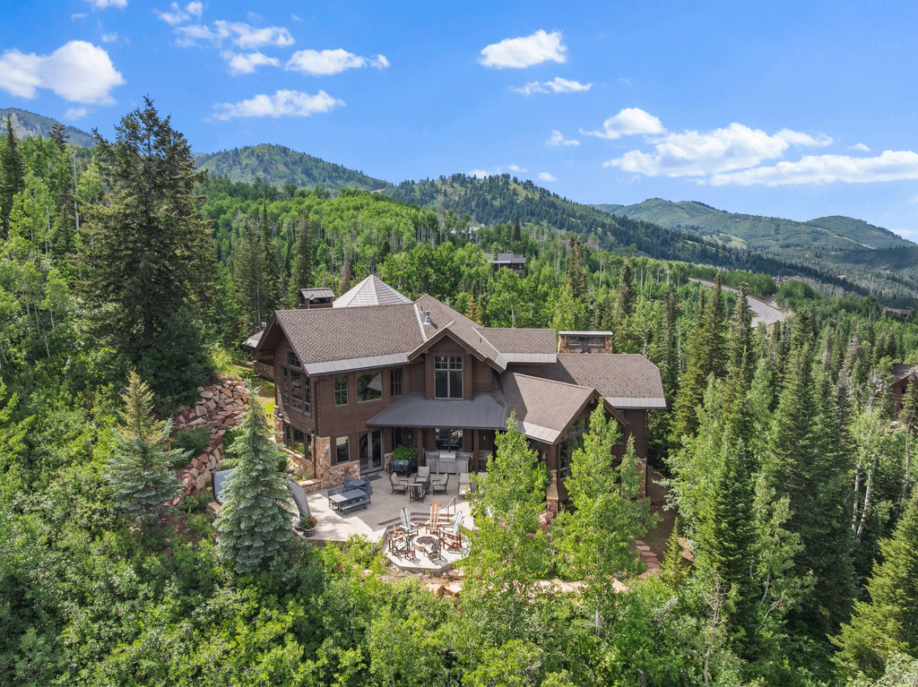 Multi-level mountain-style residence featuring a prominent stone facade and dark wood siding