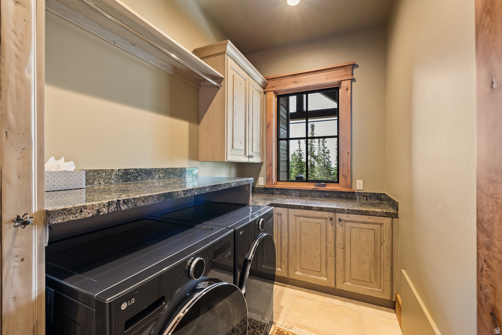Dedicated laundry area featuring granite countertops, wood-finish cabinetry, built-in shelving, and a grid-paned window with wood trim