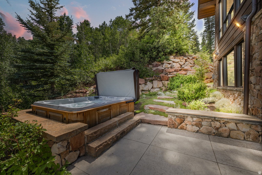 Outdoor spa with wood-finish siding set on a stone-faced concrete patio