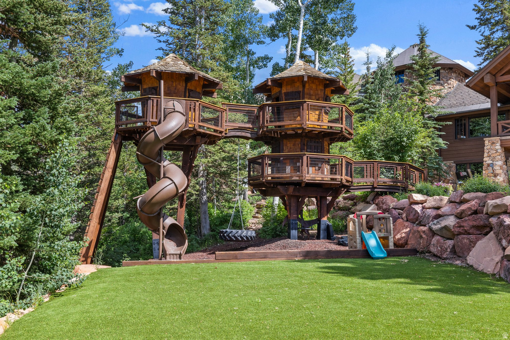Custom treehouse structure featuring multiple levels, connecting walkways, and a spiral slide