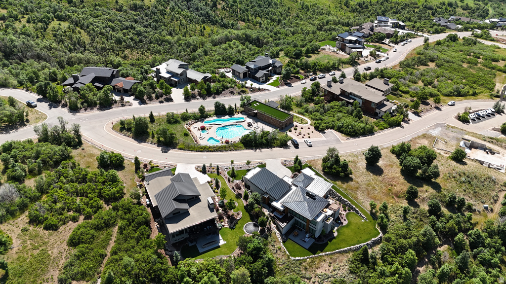 Aerial perspective showcasing multiple properties nestled within a verdant, hilly landscape