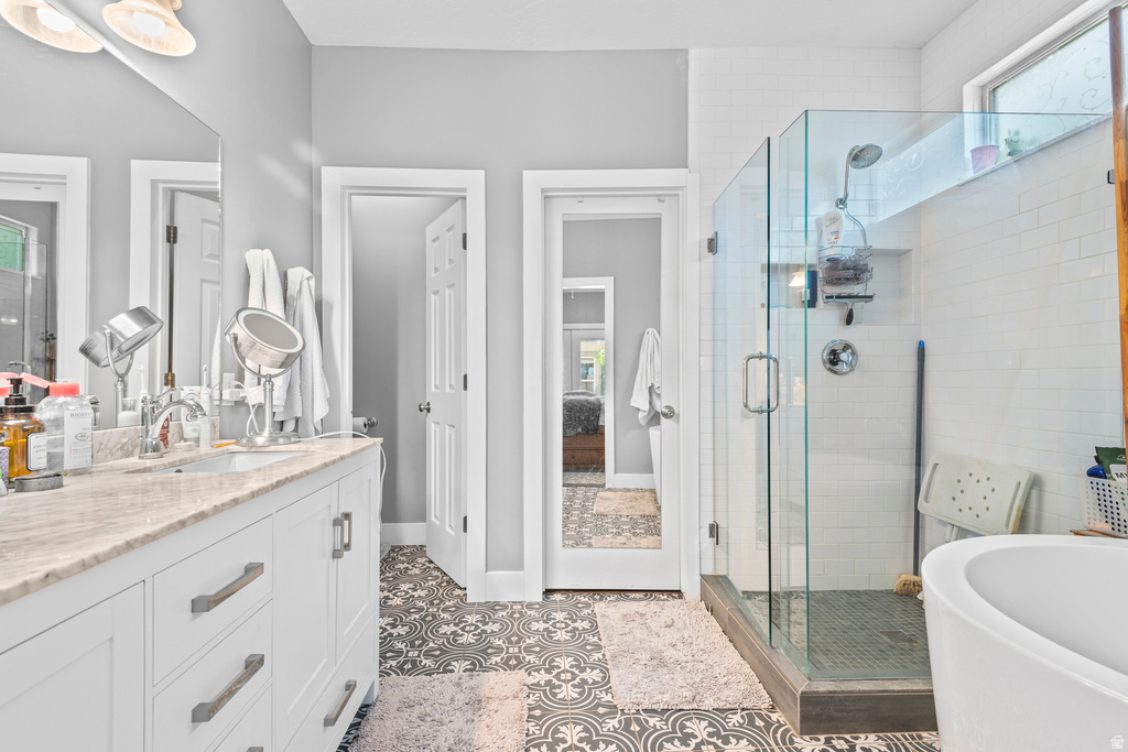 Bathroom with a double vanity featuring a light-colored countertop and white cabinetry with brushed nickel hardware