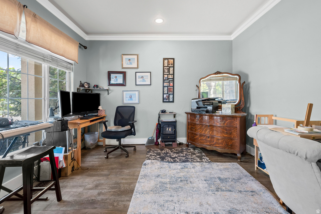 Spacious room featuring wood-finish flooring, a large window with natural light, crown molding, and recessed lighting