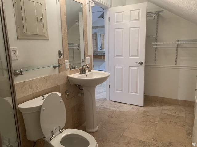 Bathroom featuring a pedestal sink, a toilet, and a glass-enclosed shower