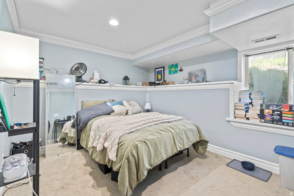 Carpeted room with crown molding, recessed lighting, and a built-in shelf feature