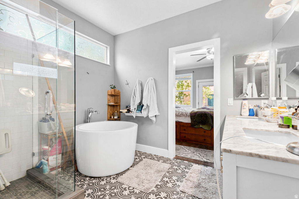 Contemporary bathroom featuring a freestanding soaking tub, glass-enclosed shower, patterned floor tile, and a double vanity with a stone countertop