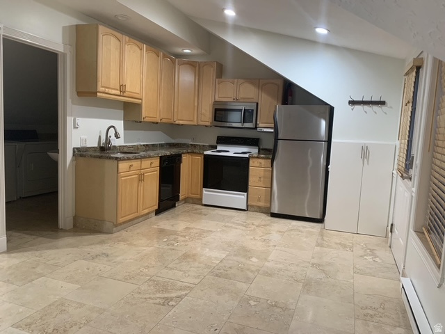 Kitchen featuring light wood cabinetry, stone countertops, stainless steel appliances, and large format tile flooring