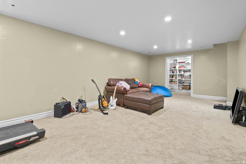 Spacious carpeted room featuring recessed lighting, light-toned walls, and a built-in shelving unit