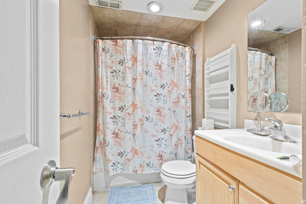 Bathroom with a light wood-finish vanity, integrated sink, and chrome faucet