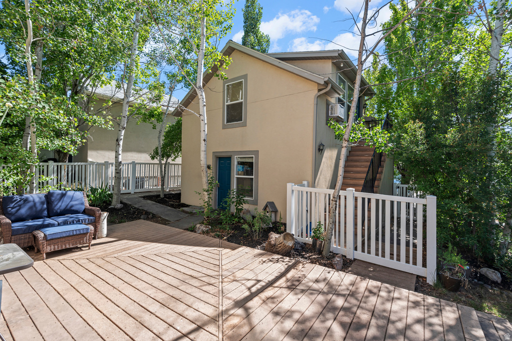 Expansive outdoor deck featuring wood-finish flooring and a white picket fence