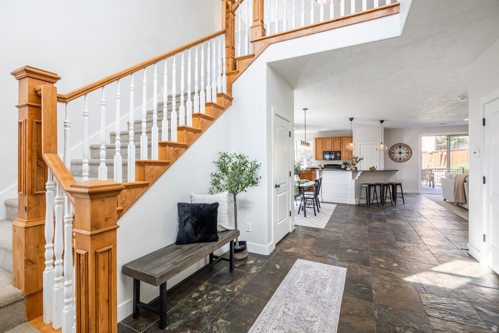Staircase with wood newel posts and handrails, white spindles, and carpeted treads