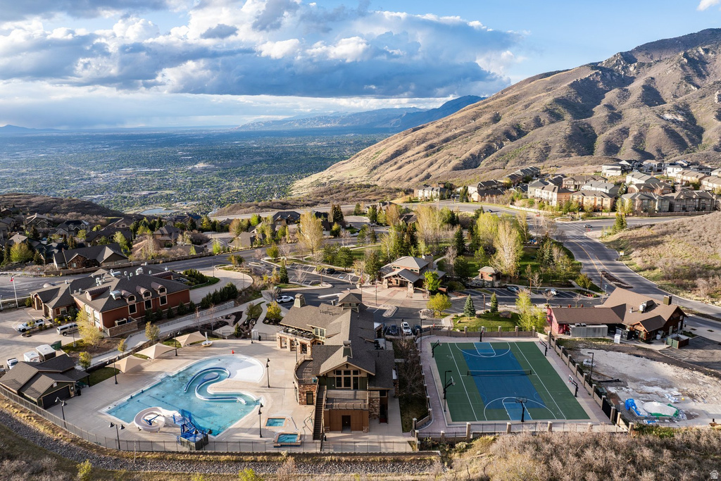 Expansive community amenities including a large swimming pool with water features, a basketball court, and a tennis court
