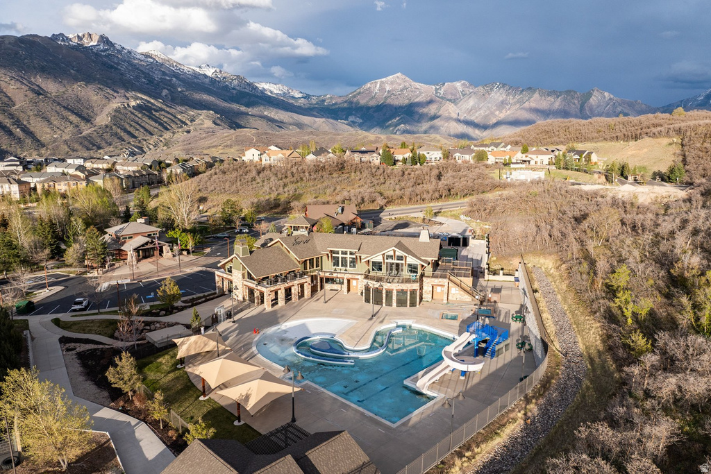 Resort-style pool complex featuring multiple swimming areas, water slide, and shaded lounge spaces