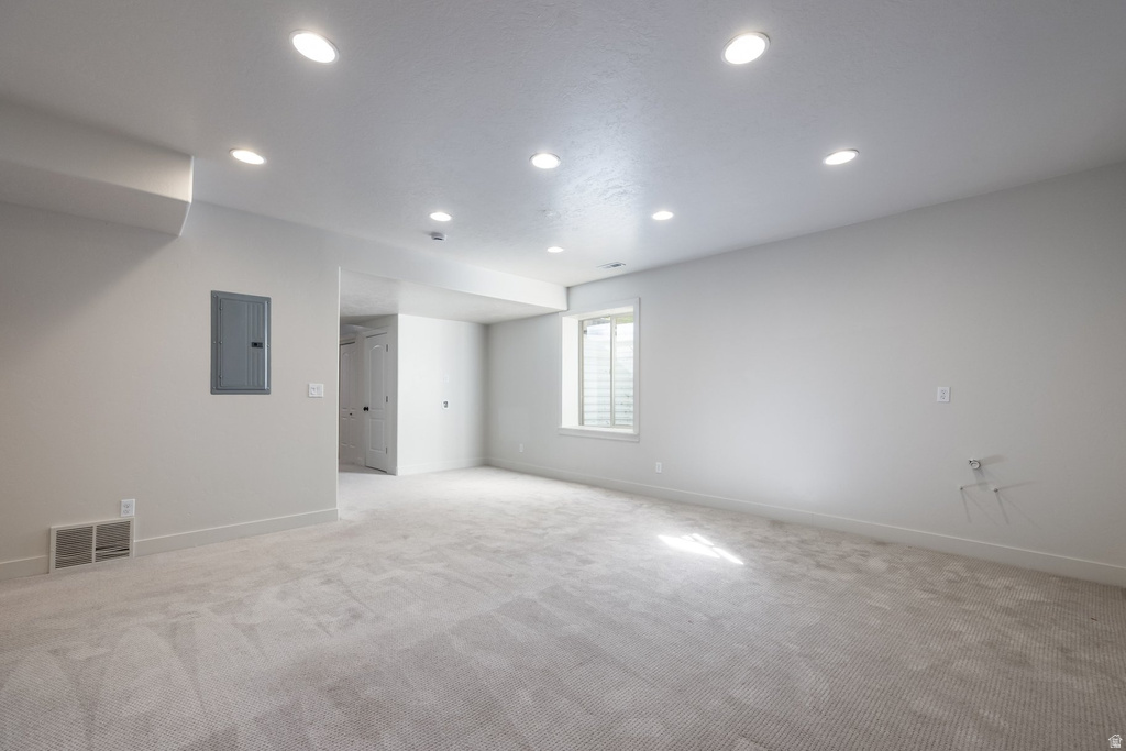 Spacious room featuring light-colored carpet, recessed ceiling lighting, and a neutral wall palette