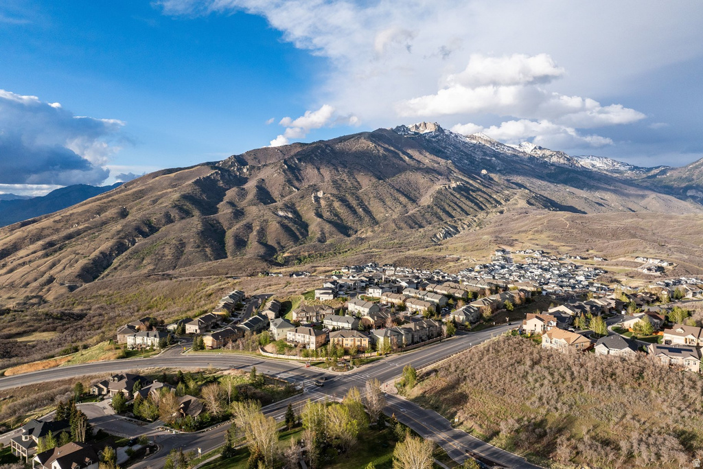 Mountainous terrain with a residential development featuring varied rooflines and a network of paved roads