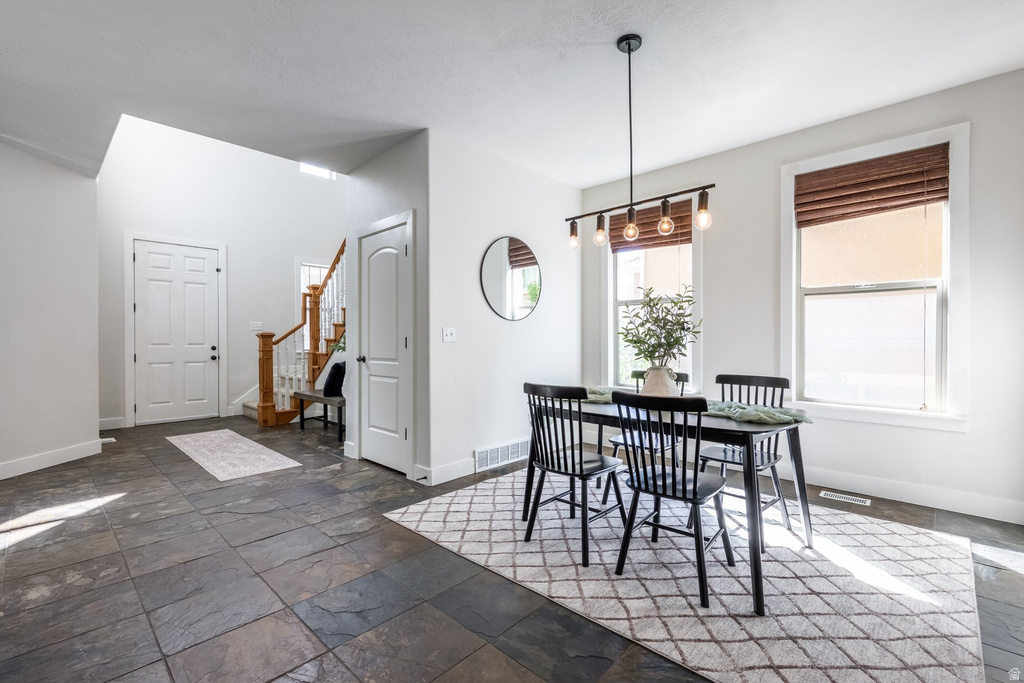 Entryway and dining area featuring slate-style tile flooring and neutral wall tones