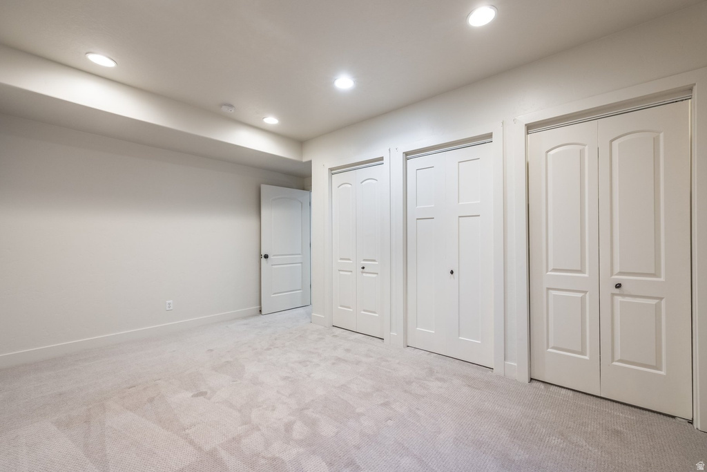 Carpeted room featuring recessed lighting, a neutral wall color, and multiple white panel doors