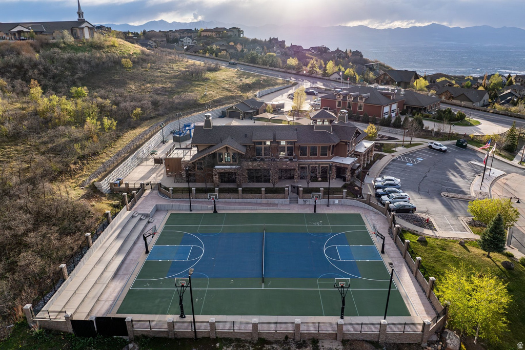 Multi-use sports court featuring basketball hoops and a tennis net